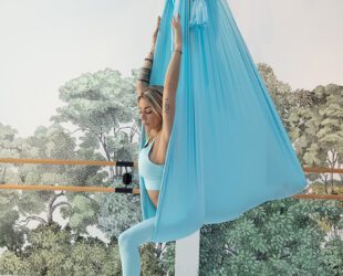 Photo d'Ornella, professeure de Yoga en pleine posture de Yoga aérien.