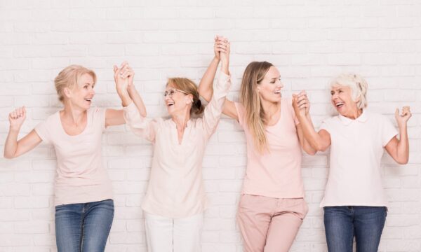 Photo de femmes de différents âges se donnant la main en souriant