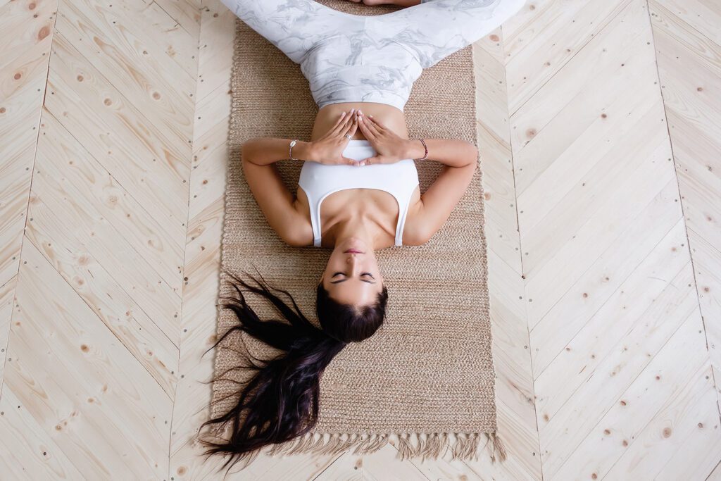 Photo d'une femme allongée sur un tapis de yoga qui se tient le ventre