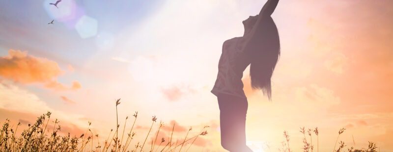 Une photo d'une femme dans la nature qui s'étire et qui semble se reconnecter à elle